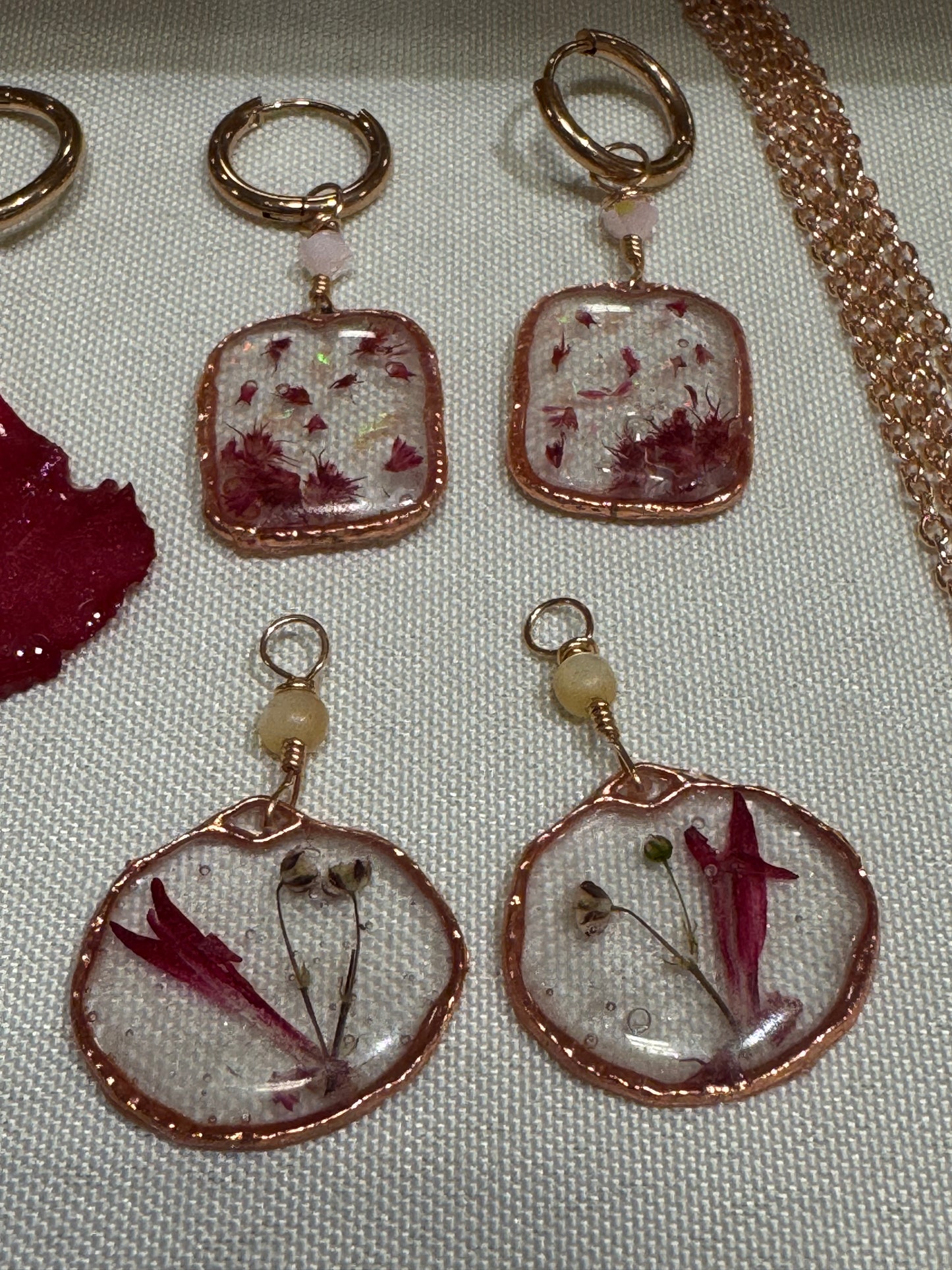 Interchangeable huggie hoop earring set featuring rose gold plated huggie hoops and 4 mix-and-match charm pairs made from client’s bridal bouquet florals.